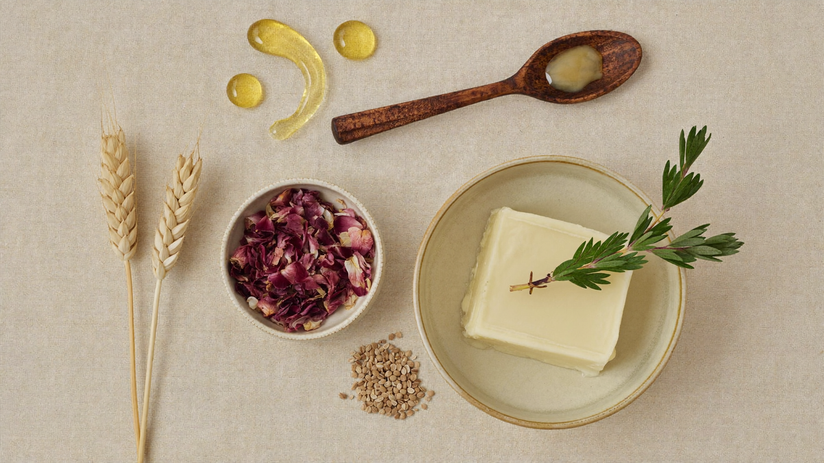 Ingrédients naturels certifiés COSMOS NATURAL : beurre de karité, romarin, blé et vitamine E sur fond de lin beige