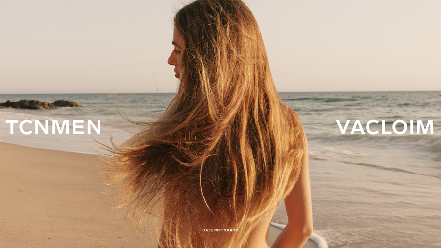Femme aux cheveux longs et brillants face à l'océan au coucher du soleil, symbole de la réparation capillaire après l'été